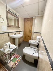 uma casa de banho com um lavatório, um WC e um espelho. em Lovely holidays em Benidorm