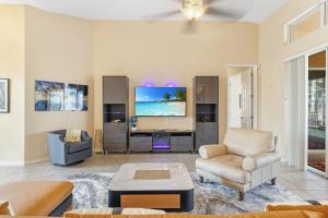 Una sala de estar con un sofá y un televisor. en Luxury Waterfront Villa - Heated Pool and Spa with Direct Gulf Access - American Dream - Roelens, en Cabo Coral