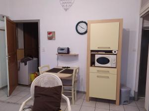 eine kleine Küche mit einem Tisch und einer Mikrowelle in der Unterkunft Cocoon Zen in Amélie-les-Bains-Palalda