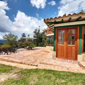 un patio con una puerta de madera junto a una casa en CABAÑA VILLA LUISA de LEYVA en Villa de Leyva