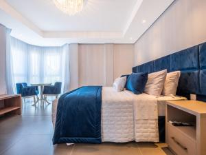 ein Schlafzimmer mit einem großen Bett mit blauem Kopfteil in der Unterkunft Hotel Locanda Casa D'Oro in Gramado + 53 Fotos