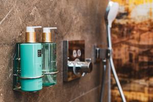 a bathroom with two green bottles on a wall at Villa Sonnenhof Boutique-Hotel in Bad Reichenhall