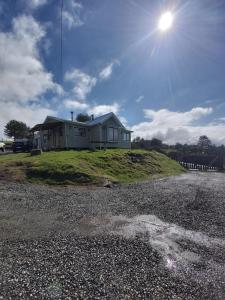 a house sitting on top of a grassy hill at Cabañas El Maitén in Castro