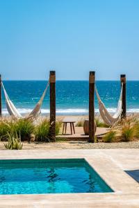 un complejo con piscina, hamacas y playa en Norte Suites Boutique, en Los Órganos