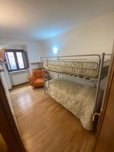 2 łóżka piętrowe w pokoju z drewnianą podłogą w obiekcie Residence Cavallino Bianco w mieście Terminillo