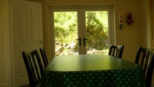 een tafel en stoelen met een tafel en een raam bij Craigalappan Cottages Holiday Home in Bushmills