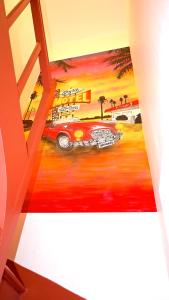 een kamer met een schilderij van een auto op de vloer bij VINTAGE Maison 9mn Astérix Chantilly 15mn Aeroport CDG in Survilliers
