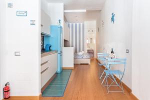uma cozinha com armários brancos e detalhes azuis em SAILING em Cagliari
