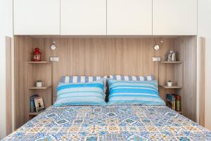 a bed with two blue pillows in a bedroom at SAILING in Cagliari