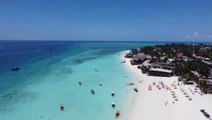 an aerial view of a beach with people in the water at Max Hotel Nungwi in Nungwi