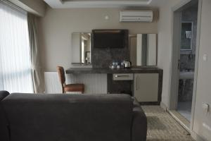 a living room with a couch and a flat screen tv at Prusias Otel in Bursa