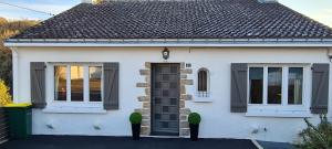 a white house with a black door and windows at MAISON APPARTEMENT LA BAULE LES PINS in La Baule