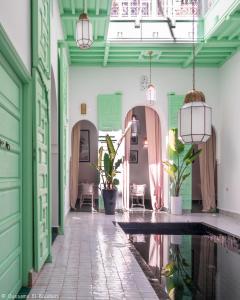 a swimming pool in a house with green doors and potted plants at Riad Dar Rabiaa in Rabat