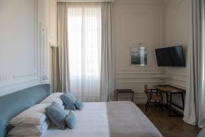 a bedroom with a bed with blue pillows and a television at Dimora Palanca in Florence