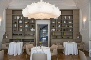 a dining room with tables and chairs and a chandelier at Dimora Palanca in Florence