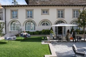 una casa con gente sentada en sillas en un patio en Dimora Palanca, en Florencia