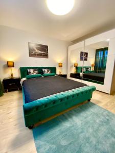 a bedroom with a large bed with a green couch at City Center Premium Apartment - Buchs SG in Buchs