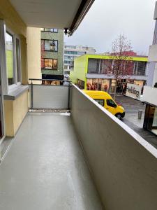 a balcony with a yellow car on a city street at City Center Premium Apartment - Buchs SG in Buchs