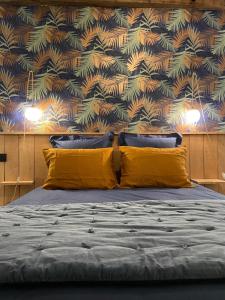 a bedroom with a bed with yellow pillows and a wallpaper at Domaine de la Bigottière in Montigné-le-Brillant