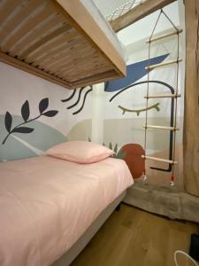 1 dormitorio con 1 cama con un mural en la pared en Domaine de la Bigottière, en Montigné-le-Brillant