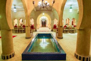 a large room with a pool of water in a building at Riad Suerteloca Merzouga in Merzouga