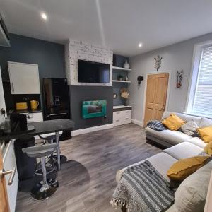 a living room with a couch and a table and a television at Kelvin Suite in Jesmond