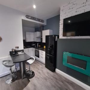 a kitchen with a black refrigerator and a table with chairs at Kelvin Suite in Jesmond