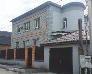 a large brick building with a garage in front of it at Апартаменты, 2 комн. 6 мест in Kropyvnytskyi