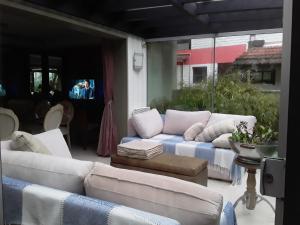 sala de estar con sofás blancos y TV en Casa Planalto, en Gramado