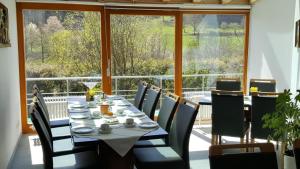 a dining room with a table and chairs and a large window at Pension Grasy in Aidlingen