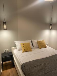 1 dormitorio con 1 cama con 2 almohadas amarillas en Central Park by LookAp, en Łódź