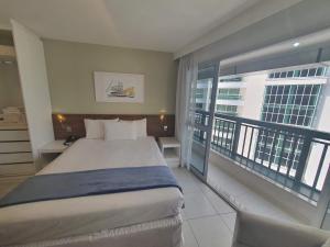 a hotel room with a bed and a large window at Flat Fusion Express By Rei dos Flats in Brasilia +50 photos