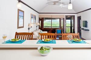 a kitchen and living room with a table with two plates of food at Santosha Barbados in Saint Andrew