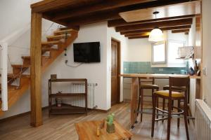 sala de estar con escalera y cocina con mesa en Meraki Lofts, en El Chaltén