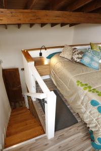 Habitación con cama, escritorio y escaleras. en Meraki Lofts, en El Chaltén