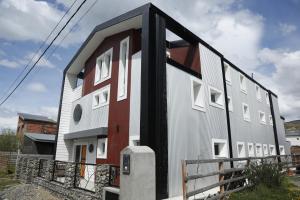 un edificio de color blanco y rojo en Meraki Lofts, en El Chaltén