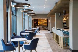 a restaurant with tables and chairs and a bar at Sheraton Suites Columbus Worthington in Columbus