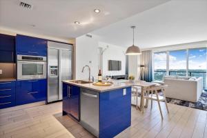 a kitchen with blue cabinets and a dining room with a table at W Residences 2 Bedroom Suite condo in Fort Lauderdale