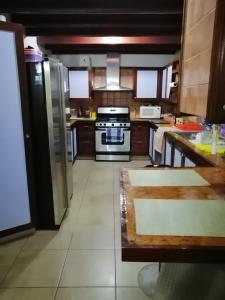 
a kitchen with a refrigerator, stove, sink and dishwasher at Villa Florie Guest House - Economic Rooms in Sosúa
