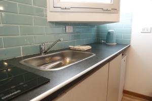 Una encimera de cocina con fregadero y azulejos azules. en Meraki Lofts, en El Chaltén 102 fotos más