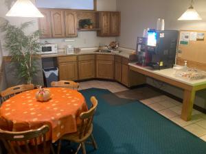 a kitchen with an orange table and a refrigerator at Landmark Motel in Clintonville