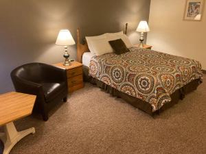 Habitación de hotel con cama y silla en Landmark Motel en Clintonville