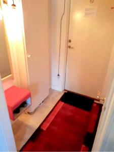 a room with a red rug and a red stool at Cosy non smoking Cabin close to beach,Alnö in Sundsvall