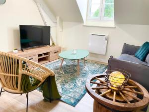 a living room with a couch and a tv at Arina & Julien Dieppe in Dieppe