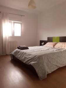 - une chambre avec un grand lit et une fenêtre dans l'établissement SX6 Ático con terraza en centro histórico Pontevedra, à Pontevedra