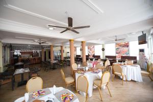 restauracja ze stołami i krzesłami oraz sufitem w obiekcie SWEET PEE EXECUTIVE HOTEL w mieście Ayeduasi