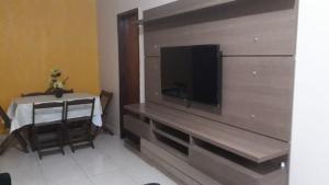 a living room with a table and a large television at Recanto chalenger in Campos dos Goytacazes