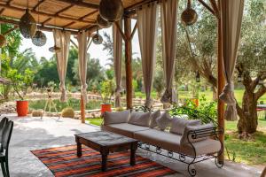 a porch with a couch and a table at Domaine Alma Marrakech in Marrakech