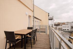 balcón con mesa y sillas de madera en ZION Apartments en Neuwied