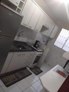 una piccola cucina con lavello e frigorifero di Recanto chalenger a Campos dos Goytacazes